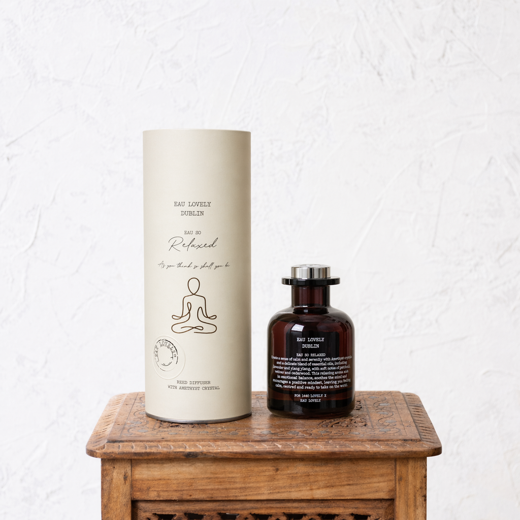 Two bottles, one tall and cylindrical, the other shorter and round, on a wooden surface with a white textured background.