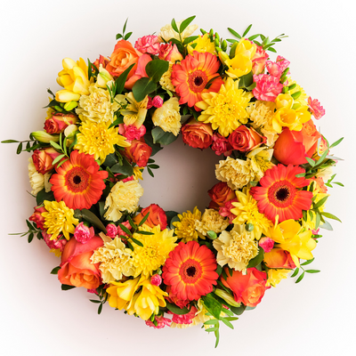 Circular orange and yellow funeral wreath handcrafted by Dublin florist The Flower Factory