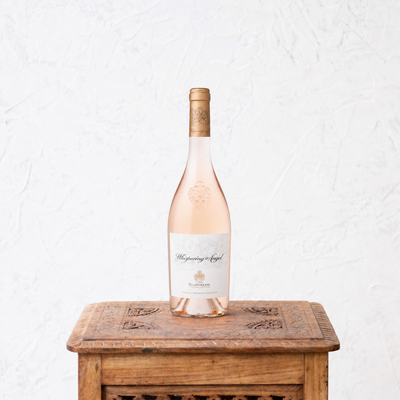 Rose wine bottle on a wooden table with a white background