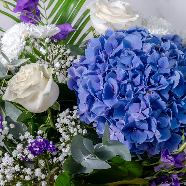 Close up of Blue Moon bouquet showing roses, hydrangea and lisianthus in soft blue and lilac